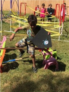 camper at summer camp going through course