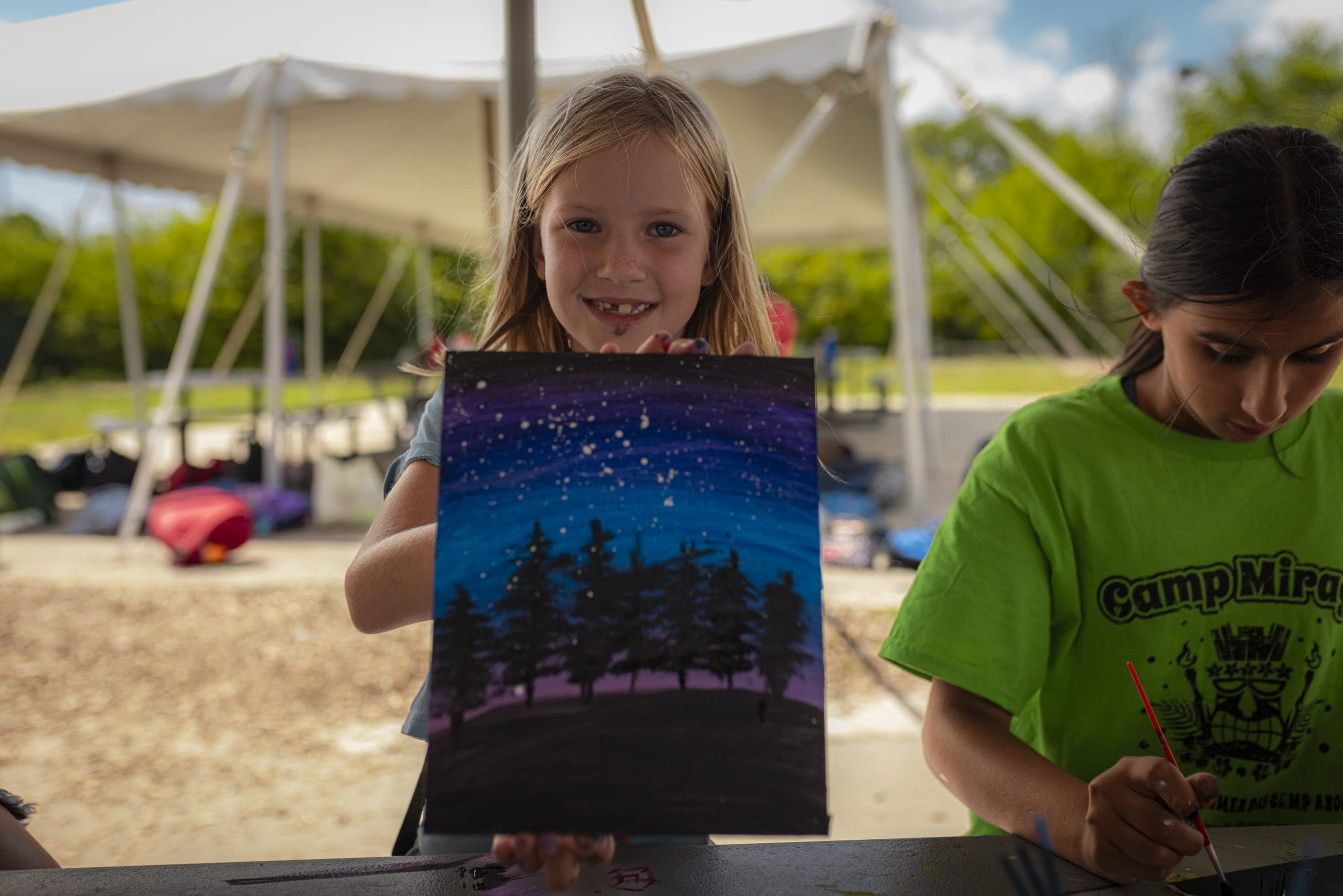 camper showing off painting made at camp